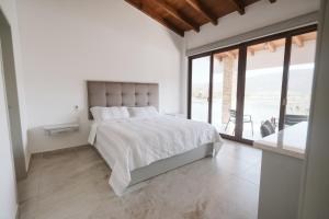 a white bedroom with a bed and a large window at Casa de Lago in Jalpan de Serra +33 photos