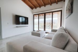 a living room with a couch and a tv at Casa de Lago in Jalpan de Serra