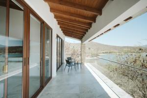 a balcony with glass doors and a view of the water at Casa de Lago in Jalpan de Serra