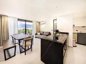 a kitchen and living room with a table and a couch at Laureles Selection Suites in Medellín