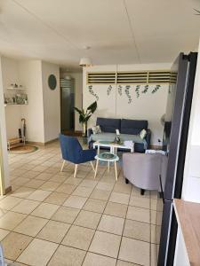 a living room with a couch and a table and chairs at Villa dix blue in Kourou