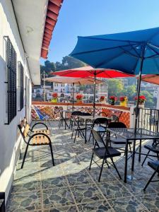 a group of tables and chairs with umbrellas on a patio at Hotel Las Palomitas in Taxco de Alarcón
