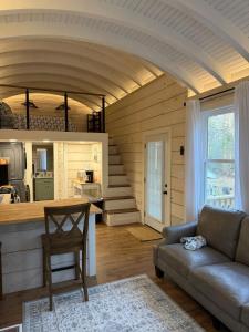 a living room with a couch and a table at Backyard Tiny House in the Woods in Tolland