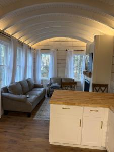 a living room with a couch and a table at Backyard Tiny House in the Woods in Tolland