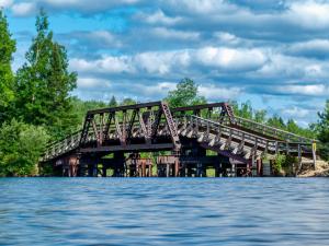 a bridge over a body of water at Four Seasons Algonquin Cabins in Madawaska