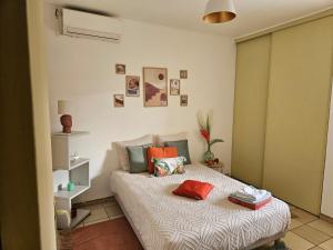 a bedroom with a bed with pillows on it at Villa dix blue in Kourou