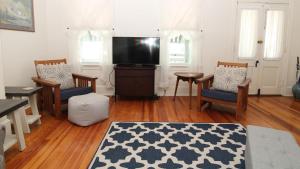 a living room with a tv and a table and chairs at The Perry Street Hideaway in Cape May