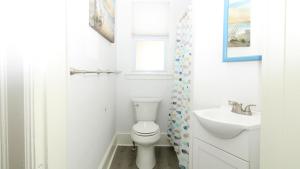 a white bathroom with a toilet and a sink at The Perry Street Hideaway in Cape May +31 photos