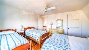 a bedroom with two beds and a ceiling fan at The Perry Street Hideaway in Cape May