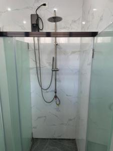 ein Badezimmer mit Dusche und weißen Marmorwänden in der Unterkunft Sanibelle Hotel in Coron + 3 Fotos