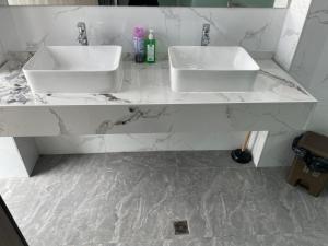 zwei Waschbecken in einem Badezimmer mit Marmorarbeitsplatten in der Unterkunft Sanibelle Hotel in Coron
