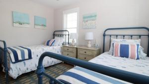a bedroom with two beds and a dresser at Seashell Sanctuary in Cape May +30 photos