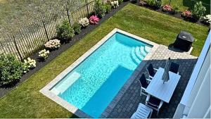 a swimming pool in a yard with chairs and flowers at Seashell Sanctuary in Cape May
