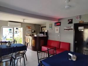 a restaurant with red chairs and tables and a counter at Hgen Rooms & Suites in Los Mochis