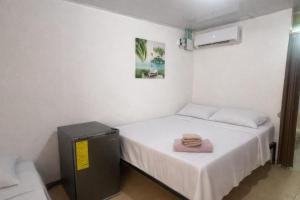 ein kleines Zimmer mit zwei Betten und einem Fernseher in der Unterkunft Bread Fruit Lodge in San Andrés
