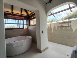 a bathroom with a large tub and a window at Hotel Boutique El Carmel in Villa de Leyva