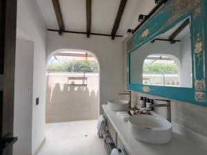 a bathroom with two sinks and a mirror at Hotel Boutique El Carmel in Villa de Leyva