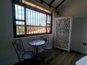 a room with two chairs and a table and a window at Hotel Boutique El Carmel in Villa de Leyva