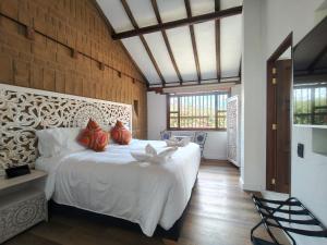 a bedroom with a large white bed with red pillows at Hotel Boutique El Carmel in Villa de Leyva +112 photos