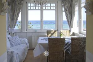 a dining room with a table and chairs and the ocean at Villa Hansa am Meer in Timmendorfer Strand