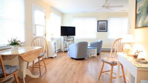 a living room with a table and chairs and a television at Marilyns Cottage in Cape May