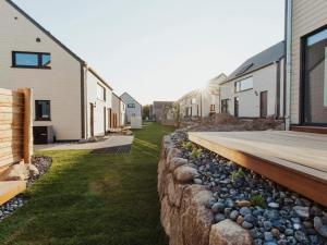 a backyard with a retaining wall and a wooden deck at Urlaub genießen in Sagard auf Rügen in Sagard