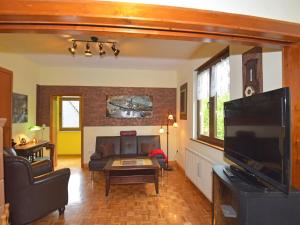 a living room with a couch and a flat screen tv at Ferienwohnung im Erholungsort in Kurort Steinbach-Hallenberg