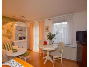 a living room with a table and chairs and a television at Ferienwohnung im Erholungsort Suhl in Suhl +4 photos