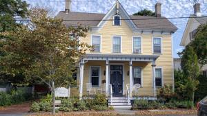 a yellow house with a blue door on a street at The Bayberry House in Cape May