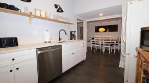 a kitchen with white cabinets and a black dishwasher at The Bayberry House in Cape May