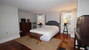 a bedroom with a bed and a chair and a table at The Bayberry House in Cape May