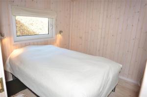 a white bed in a room with a window at 30835-Ulfborg-Kornblomstvej-409 in Ulfborg
