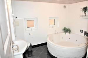 a white bathroom with a large tub and a toilet at 30835-Ulfborg-Kornblomstvej-409 in Ulfborg +10 photos