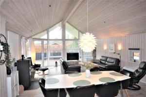 a living room with a table and chairs at 30835-Ulfborg-Kornblomstvej-409 in Ulfborg