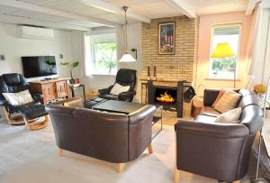 a living room with leather furniture and a fireplace at 30073-Ulfborg-Grastensborgvej-35 in Ulfborg