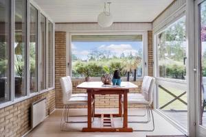 a screened in porch with a table and chairs at 30073-Ulfborg-Grastensborgvej-35 in Ulfborg