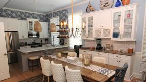 a kitchen with a dining table and a kitchen with white cabinets at Breezes On Broad in Cape May