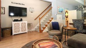 a living room with a flat screen tv and a couch at Breezes On Broad in Cape May