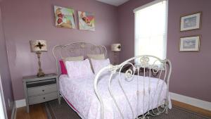 a bedroom with a white bed and a window at Breezes On Broad in Cape May