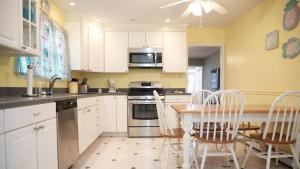 a kitchen with white cabinets and a table and chairs at 103 Broadway The Broadway Breeze in Cape May