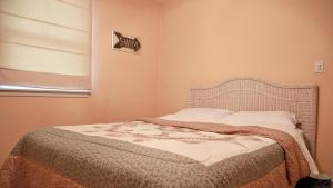 a bed in a bedroom with a window and a bedspread at 103 Broadway The Broadway Breeze in Cape May