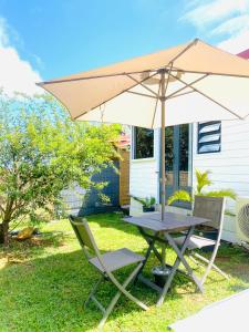 a table and two chairs and an umbrella at Villa cactus in Goyave