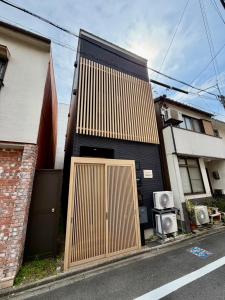 a house with a wooden door on the side of it at Villa Monica 30sec in Noritake-Shinmachi
