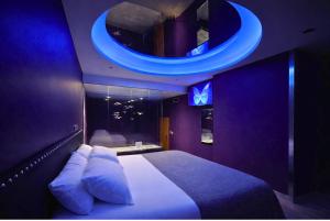 a bedroom with a large bed with a blue ceiling at V Hotel in Arroyomolinos