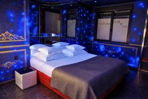 a bedroom with a large bed with blue lights at V Hotel in Arroyomolinos