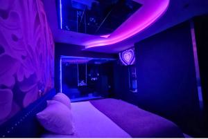 a bedroom with a bed with purple lights on it at V Hotel in Arroyomolinos +62 photos