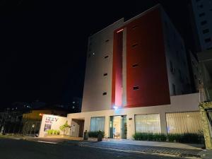 a building with a large red building at night at Izzy Hotel in Uberlândia