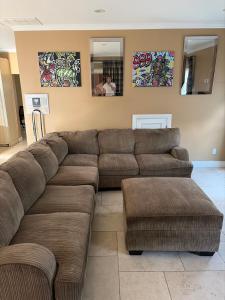 a living room with a brown couch and two mirrors at Private room with Fridge - Mini Mansion in Burbank