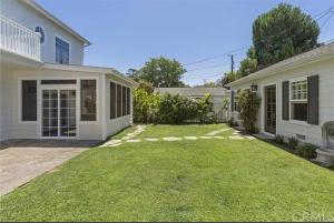 a backyard of a white house with a lawn at Private room with Fridge - Mini Mansion in Burbank