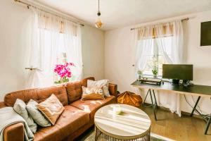 a living room with a brown couch and a table at Elegant 2 BR Apartment in Historic Cambridge in Papworth Everard